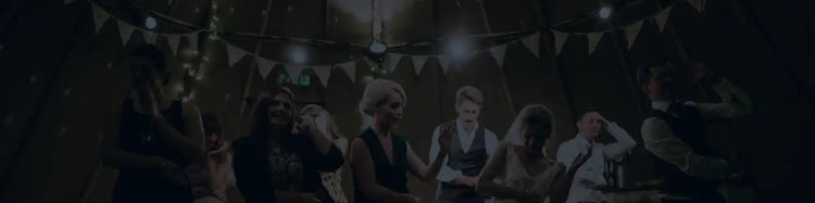 En mörk, svagt upplyst samling av människor i vad som verkar vara en festlig miljö.